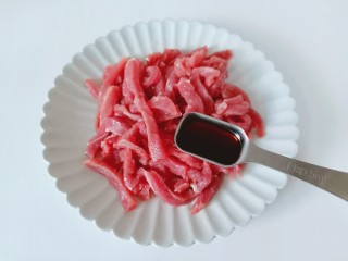 青椒炒牛肉,牛肉放在盘子里加上生抽一勺。