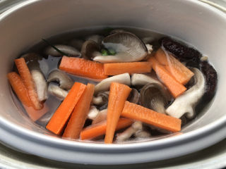 胡萝卜炖排骨,放入地平菇、胡萝卜、葱结、香菇。