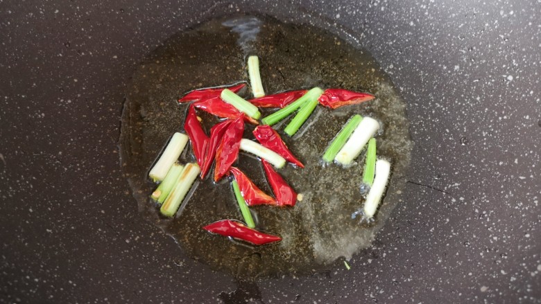 爆炒黄豆芽,炒锅内倒适量的食用油烧热，下入小葱和干红辣椒炒香。