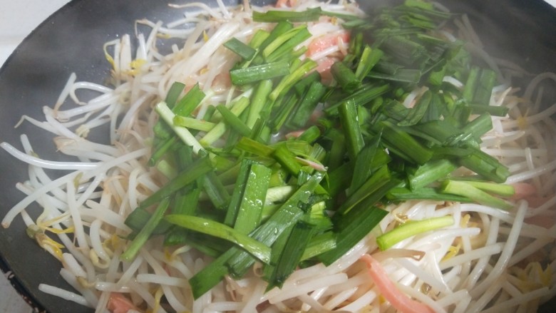 绿豆芽炒韭菜,倒入韭菜翻炒均匀。