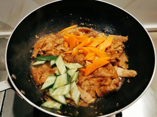 红烧油面筋,直至汤汁变少量浓稠，放入炒好的胡萝卜片和黄瓜片。