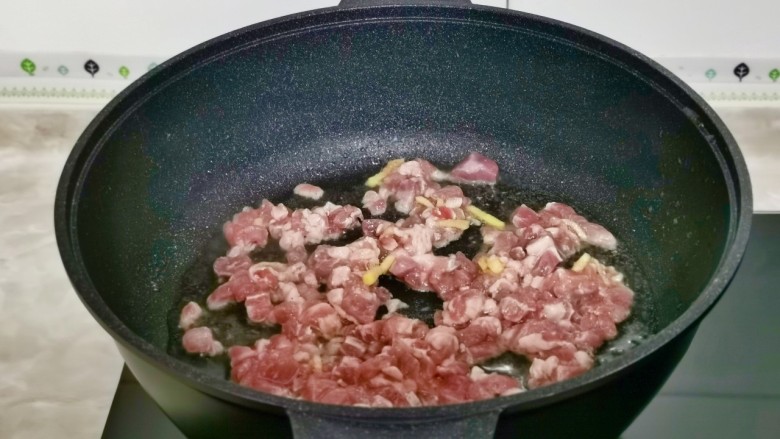牛肉粉丝煲,起油锅加入腌制好的牛肉煸炒至变色。