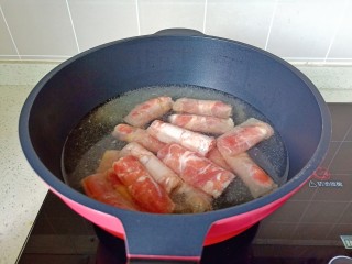 酸汤羊肉,锅里水开放了羊肉卷，料酒一勺焯水。