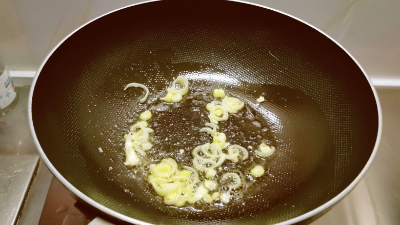 芹菜炒豆干,起油锅放入食用油，油热后放入葱片炒香。