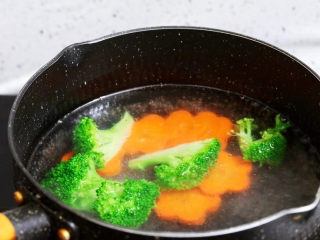 香煎龙利鱼,锅中注入清水烧开，加入1勺食用油和少许盐，再放入西兰花和胡萝卜，焯熟后捞出控干水分装入盘中备用