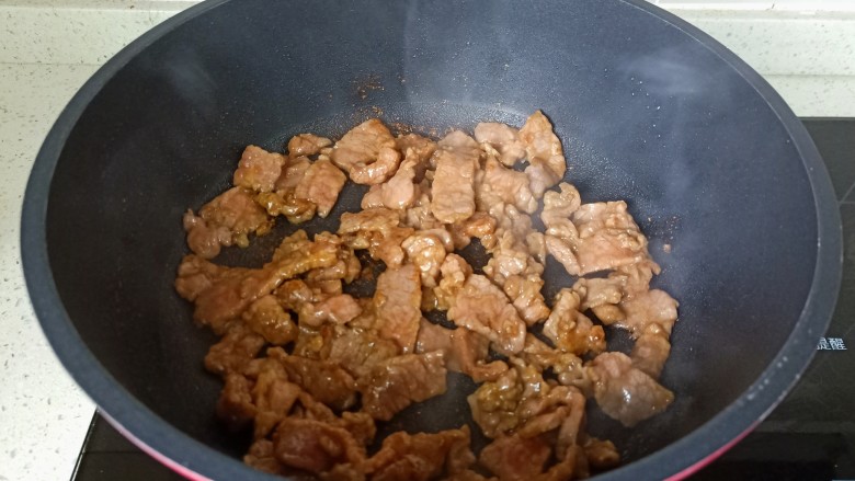 牛肉粉丝煲,翻炒至牛肉丝变色。
