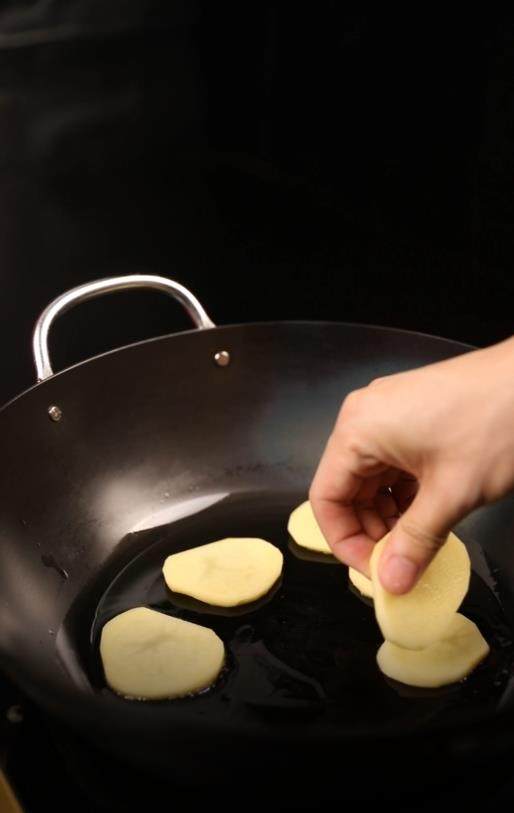 糟辣干锅土豆片,锅里热油后倒入土豆片，煎至底部焦黄再翻面