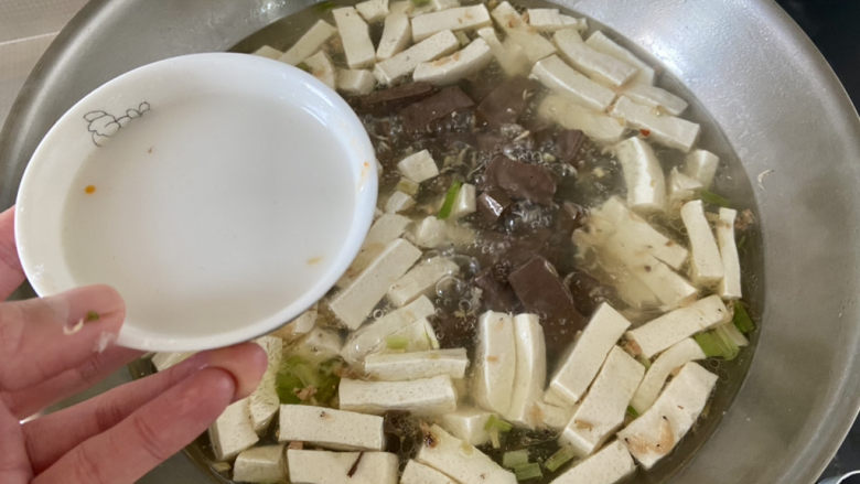 鸭血豆腐汤,开盖，转中大火，加入三汤匙水淀粉收汁，以免汤汁太过寡淡，尝下咸淡，如果觉得淡，可以添加少许盐