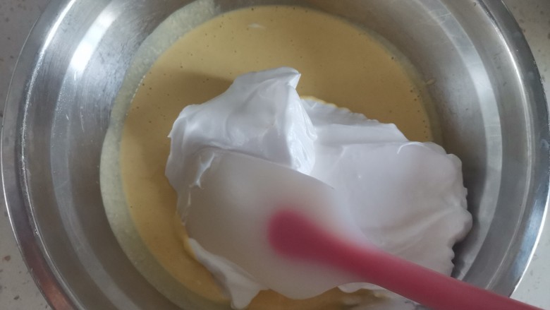 蔓越莓小米蒸糕,取1/3蛋白霜到蛋黄糊里翻拌均匀，不能画圈搅拌