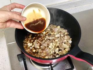 快手易学的香菇肉末拌面,再加入香菇和洋葱丁一起翻炒出香味。倒入调好的酱汁，大火煮沸收汁。
