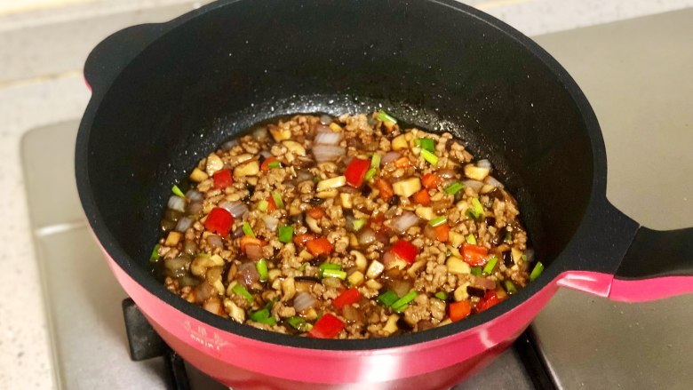 快手易学的香菇肉末拌面,最后加入香葱和红椒碎，翻炒均匀即可。
