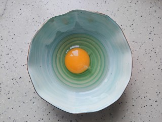香菇蒸肉饼,鸡蛋磕入碗内