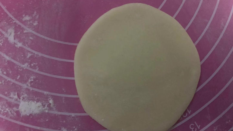 水果糯米糍,案板上撒手粉，取35克炒熟的糯米皮，擀成圆形。