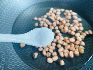 凉拌芹菜花生米,锅中加入适量清水倒入清洗干净的花生米，加入1小茶匙盐