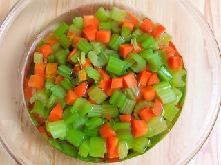 凉拌芹菜花生米,将蔬菜捞出放入碗中，倒入凉水拔一下。