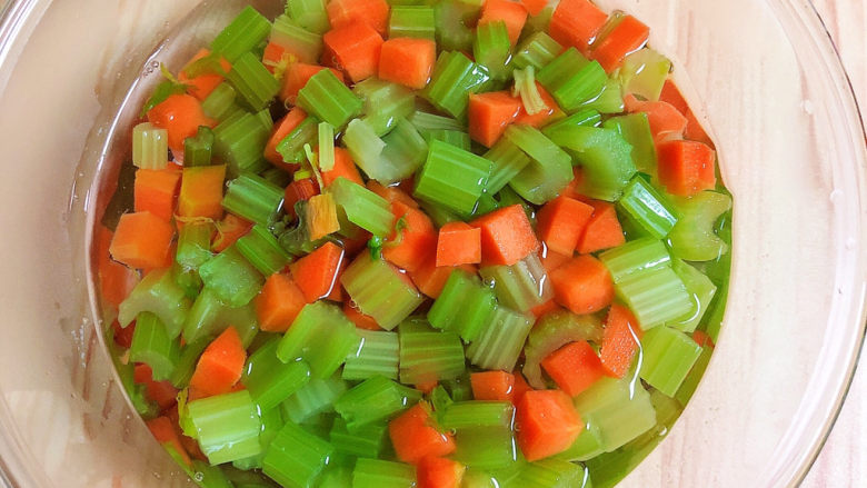 凉拌芹菜花生米,将蔬菜捞出放入碗中，倒入凉水拔一下。