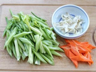 芹菜炒虾仁,芹菜摘去老叶，洗净后切成斜段。干百合提前泡发，胡萝卜去皮切斜片。