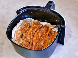 孜然烤羊排,空气炸锅烤网上先垫上锡纸，再垫一张油纸，放上腌制好的羊排。