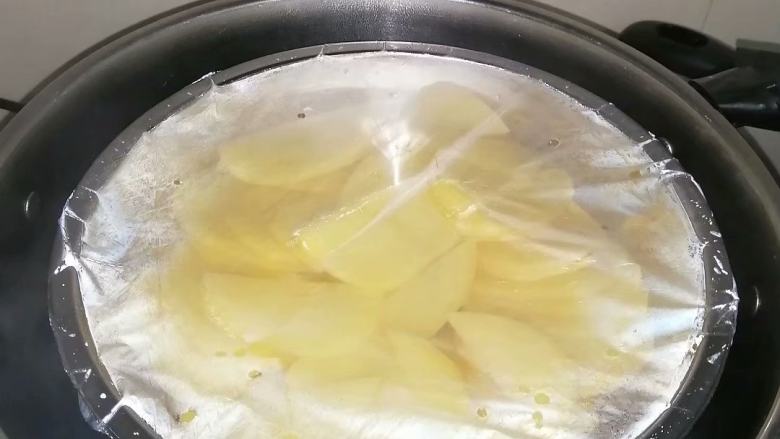 奶香土豆饼,盖上保鲜膜，上锅蒸30分钟