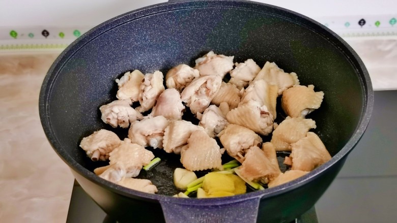 土豆炖鸡翅,起油锅加入葱姜蒜煸炒，再加入鸡翅块。