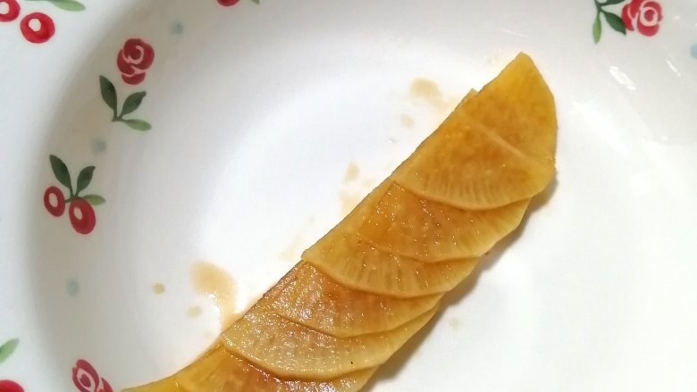 糖醋白萝卜,取切开半片的萝卜片，叠好，然后，由下往上卷起来，卷成一朵花的形状