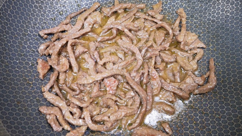 小炒黄牛肉,炒锅内倒适量的食用油烧热，下入腌好的牛肉翻炒至变色，盛出备用。 