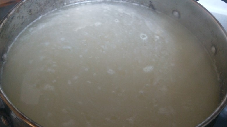 鸡肉山药粥,锅中烧开水放入小米熬制。