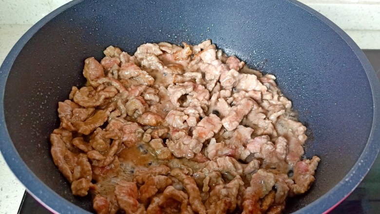 小炒黄牛肉,爆炒至牛肉丝变色，放入蒜泥炒香。