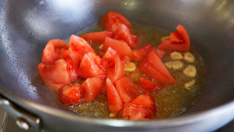 西红柿炒茄子,下入番茄煸炒出汤汁