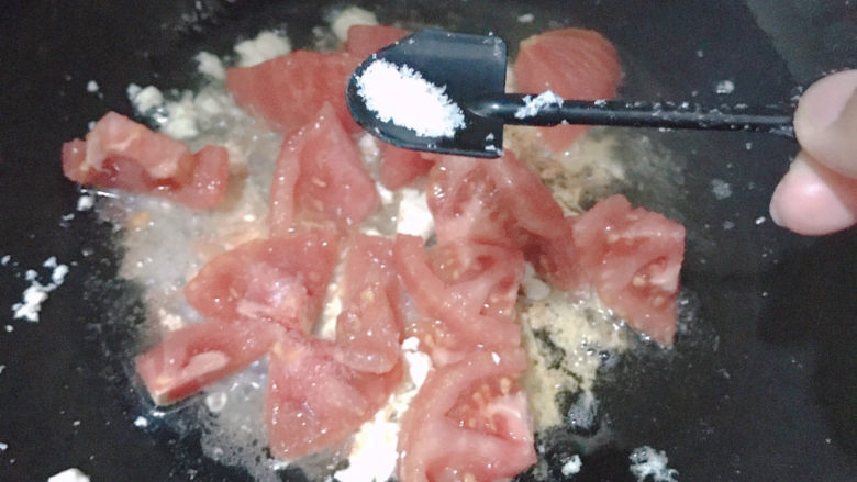 西红柿炒豆腐,倒入西红柿，加入一勺盐翻炒出汁