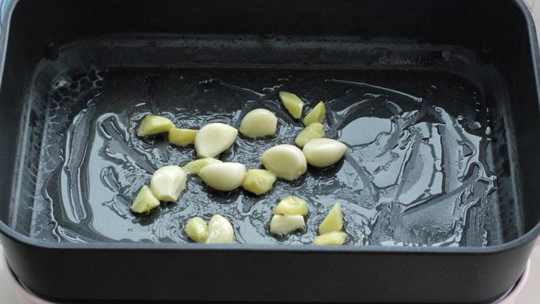 土豆炖鸡翅,在平底锅内倒入适量食用油烧热，把大蒜和姜块放进去，小火炒至大蒜微微泛黄。