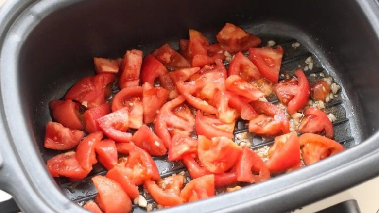 番茄肥牛,锅中倒适量食用油烧热，放入蒜末炒出香味，再把番茄放进去炒出汤汁。