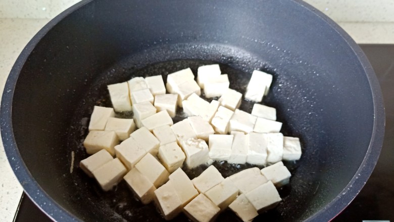 雪菜豆腐,热锅热油下豆腐煎。