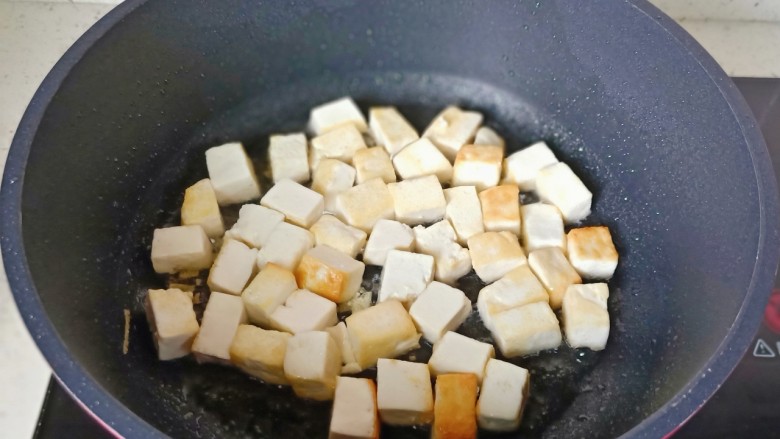雪菜豆腐,豆腐煎到两面微黄盛盘。