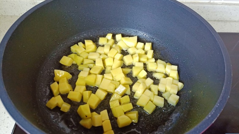 土豆炖 鸡翅,锅里放适量的食用油，放土豆丁煎。