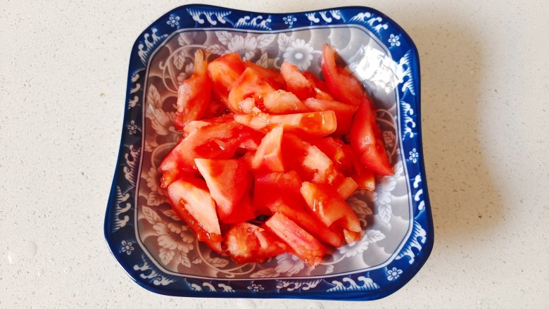 西红柿炒土豆片,处理好的西红柿切成小块装入盘中备用