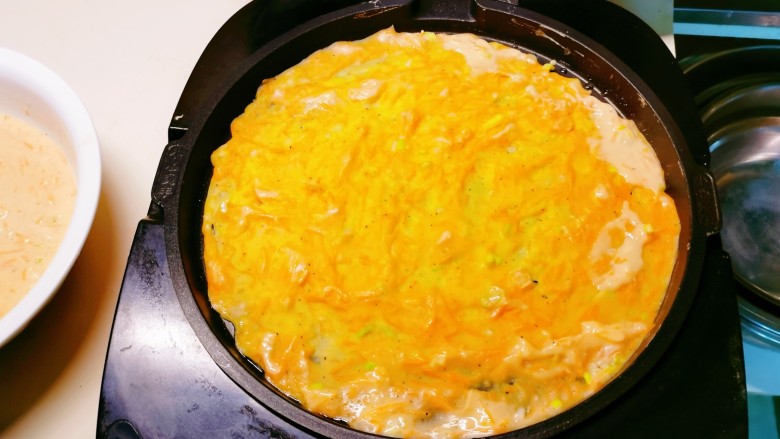 胡萝卜鸡蛋饼,均匀摊开，选择适合的功能键，开始煎制。