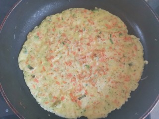 胡萝卜鸡蛋饼,待一面定型，翻过来煎另一面，直到煎至两面都金黄色即可盛出