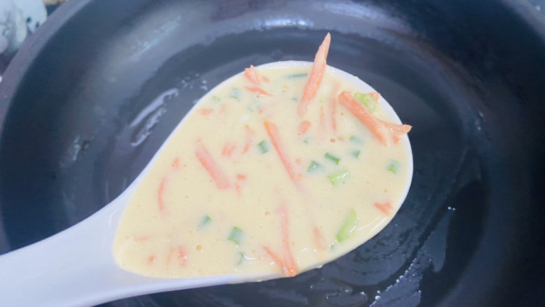 胡萝卜鸡蛋饼,锅中刷上少许油加热，舀入一勺面糊