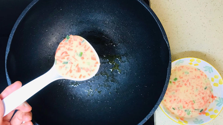 胡萝卜鸡蛋饼,用勺子舀一勺面糊，加进油锅中