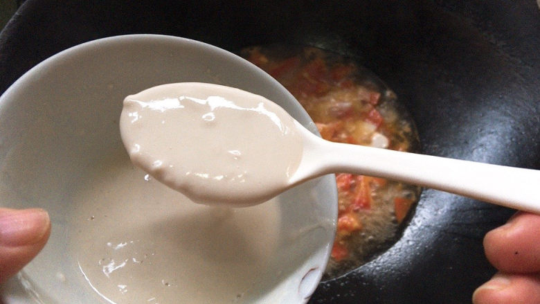 西红柿疙瘩汤,待锅中番茄汤底沸腾，一勺一勺的舀入倾倒入锅中。