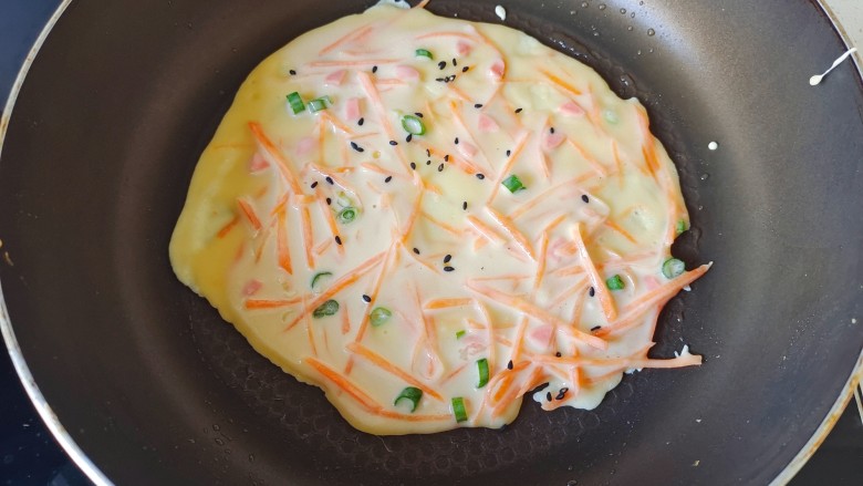 胡萝卜鸡蛋饼,加入一点黑芝麻点缀，上面面糊凝固，反面在烙一会，多翻2次即可