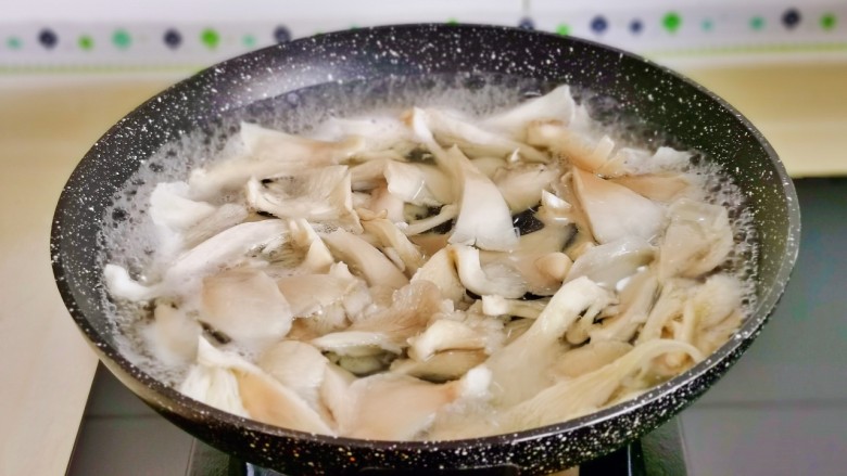 青椒炒平菇,平菇焯水，冷水下锅烧开煮1分钟捞出沥干水分。