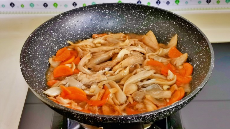青椒炒平菇,加入半碗纯净水把平菇烧熟。