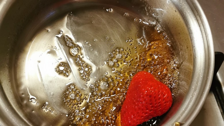 草莓糖葫芦,糖稀熬好了，放入草莓快速滚一圈，马上出锅。