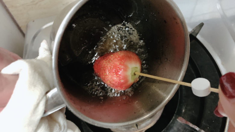 草莓糖葫芦,将草莓加入其中旋转裹上糖浆。