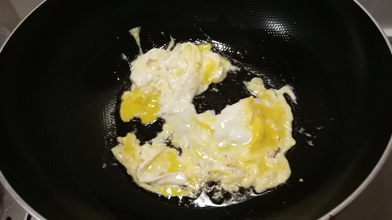青椒炒平菇,起油锅放入食用油，油热后放入鸡蛋液翻炒成大块。