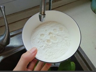 西红柿疙瘩汤,面粉放入碗中，打开水龙头以水滴的形式滴在面粉上，边搅拌边滴水
