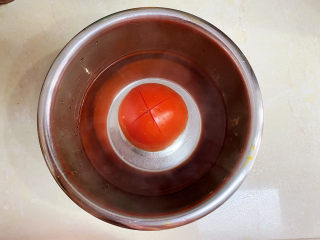 西红柿疙瘩汤,西红柿划十字开水浸泡去皮。