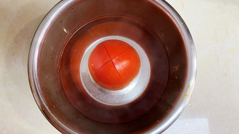 西红柿疙瘩汤,西红柿划十字开水浸泡去皮。